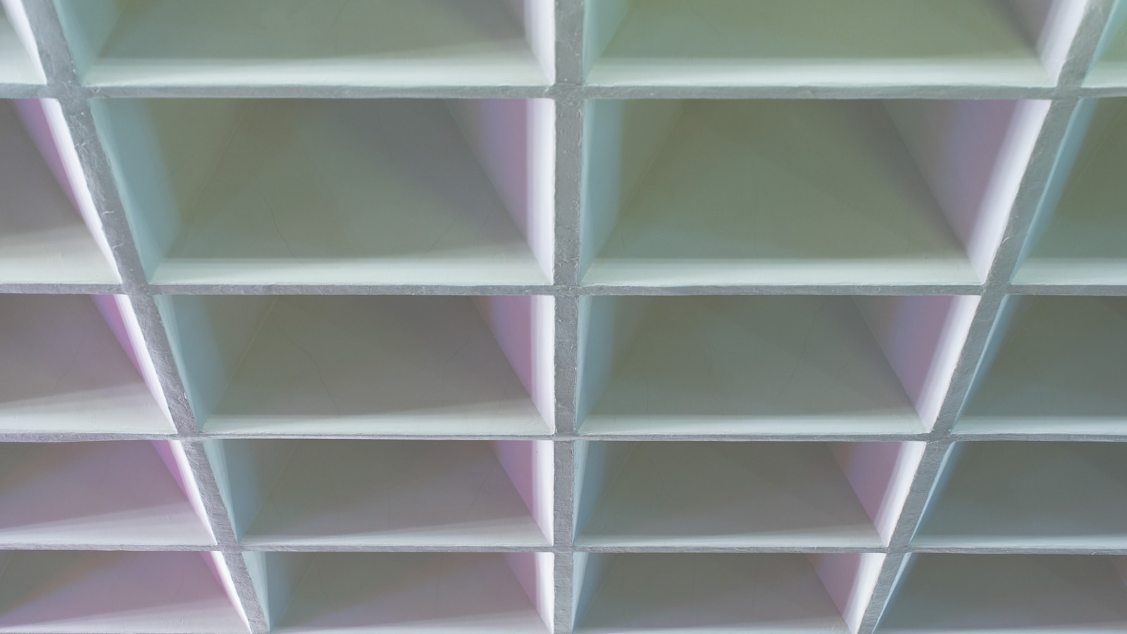 Geometric pattern of light gray squares with soft purple shadows.